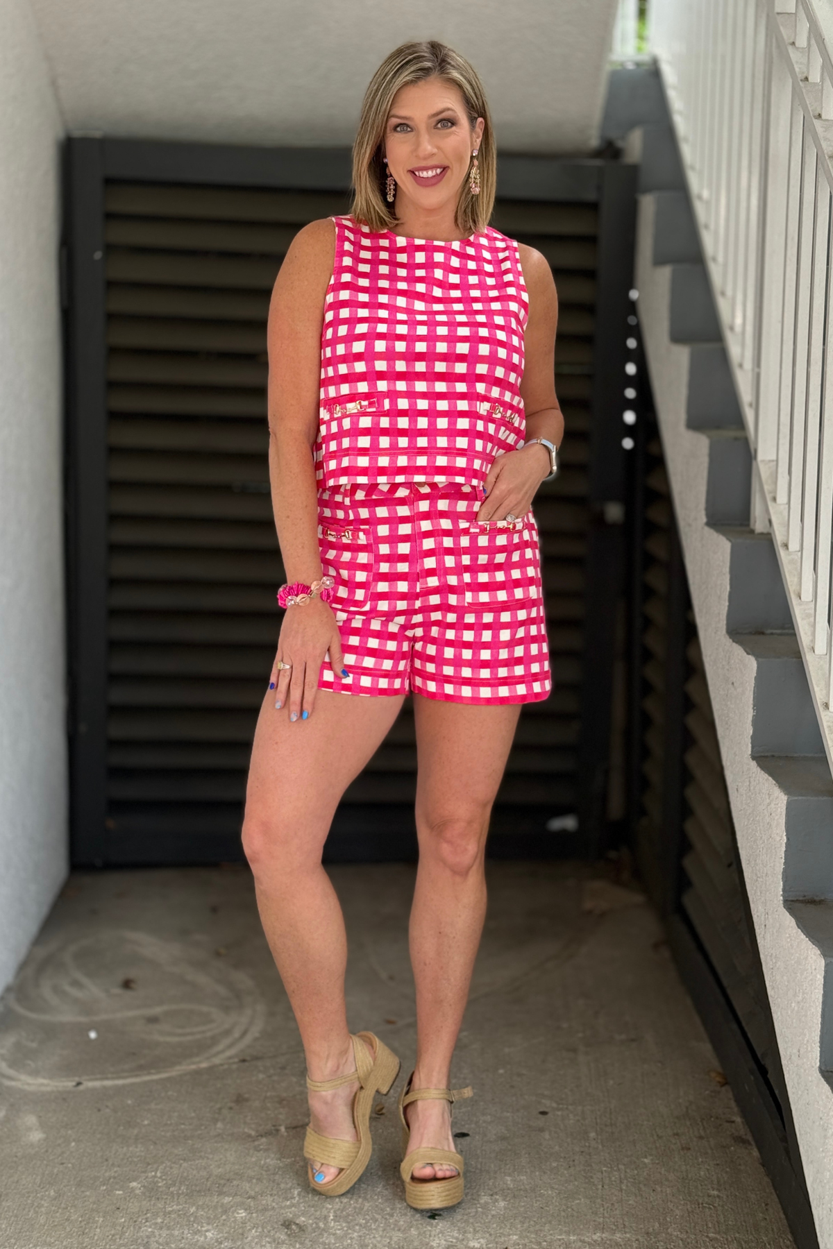 Close up of pink check shorts with front pocket gold accent