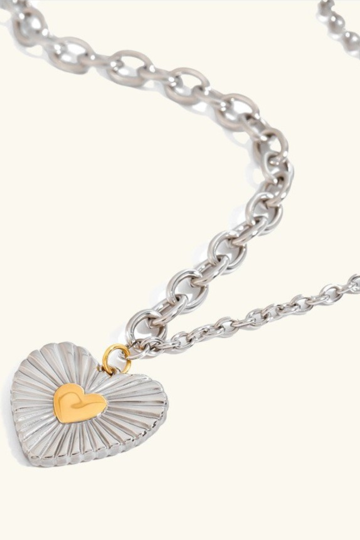 two tone silver and gold heart necklace on light background