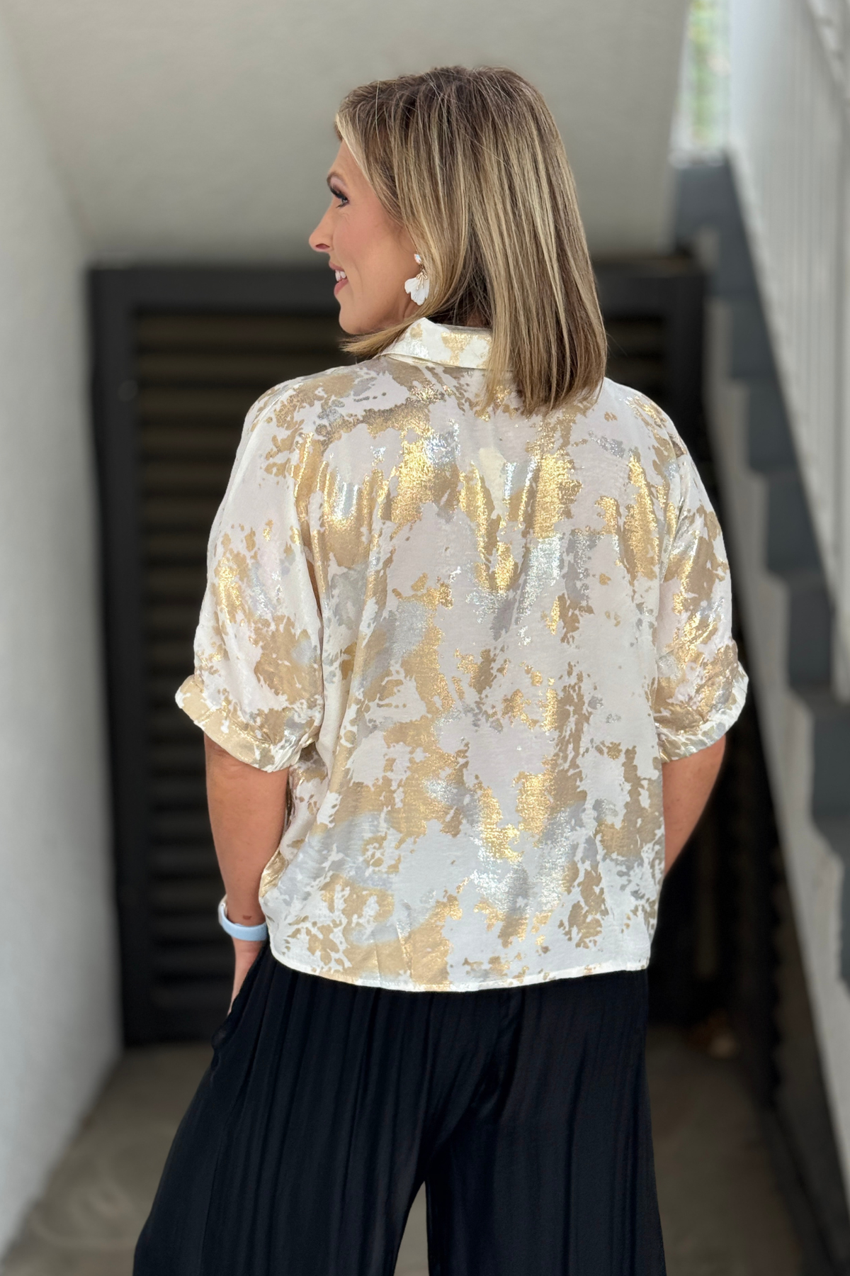 Back view of white metallic boutique blouse
Lightweight white and gold metallic top styled with black pants