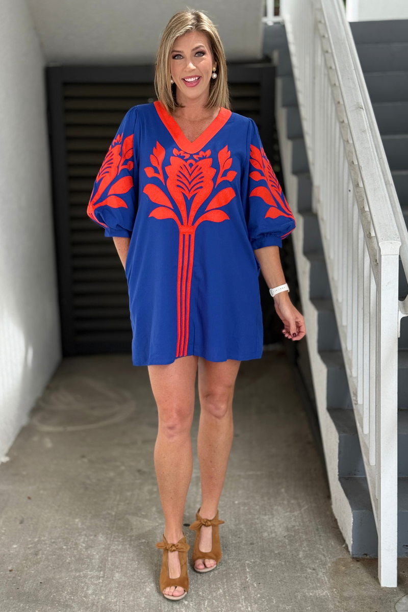 Royal blue dress with orange floral appliqué and V-neckline  