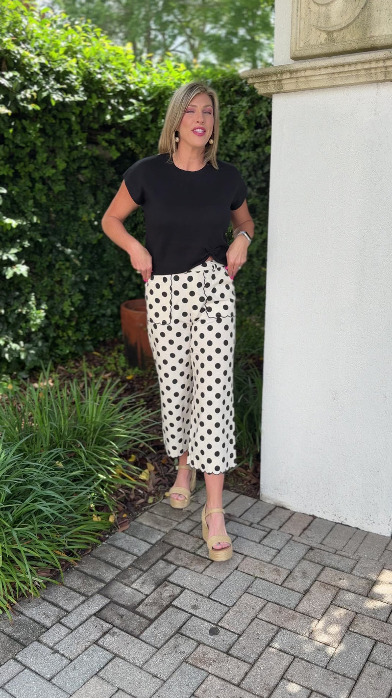 Chic black knit top paired with polka dot pants