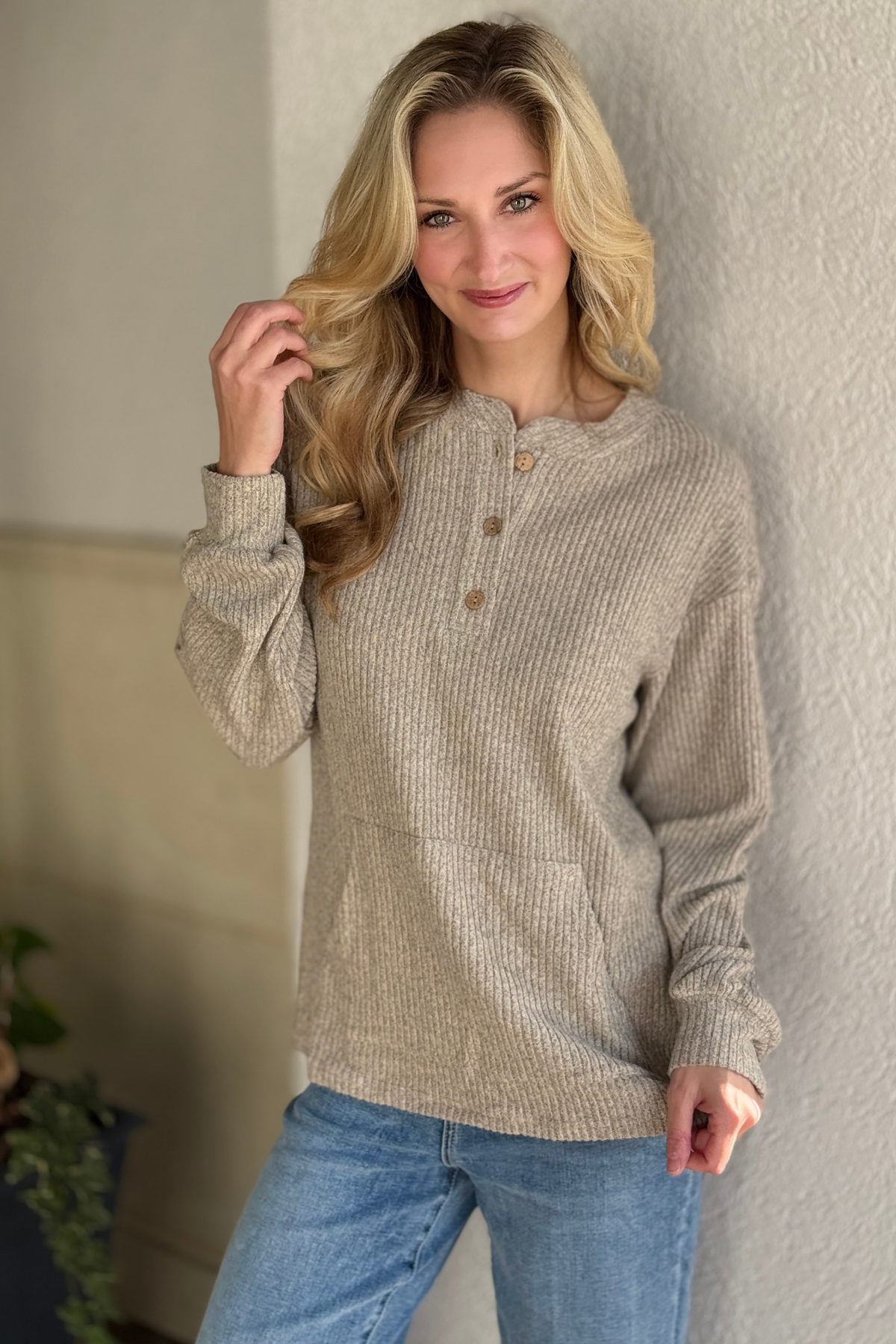 Women wearing beige ribbed henley knit top