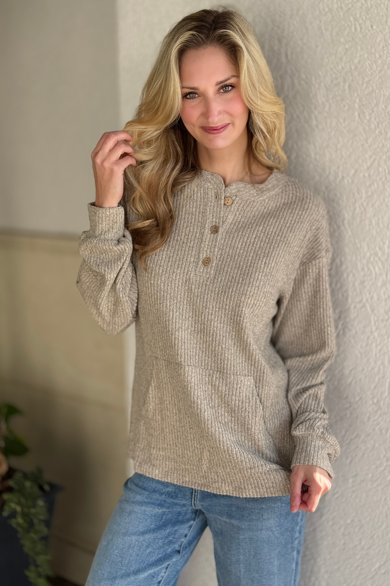 Women wearing beige ribbed henley knit top