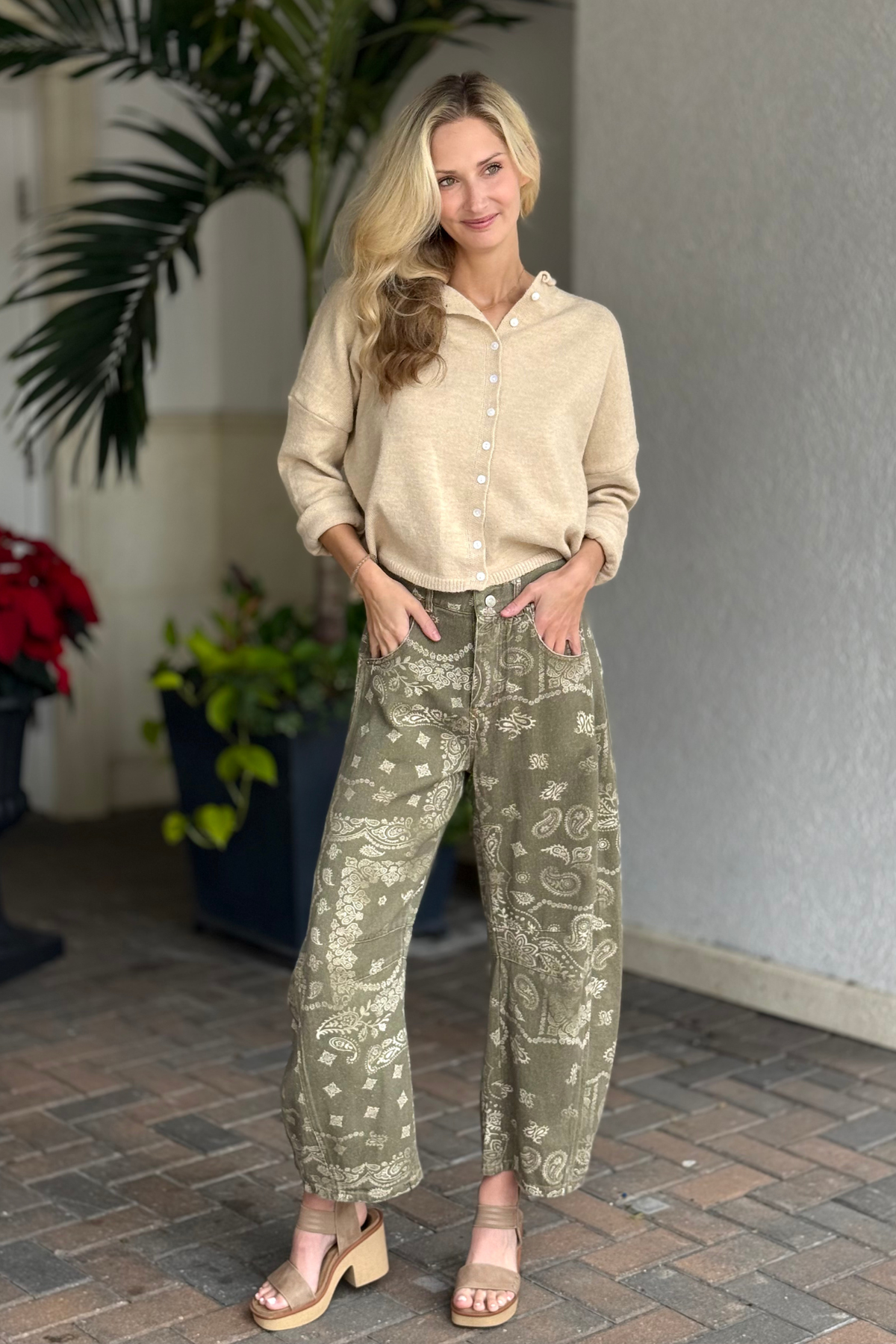 Woman wearing olive bandana print barrel-leg jeans with front pockets and a vintage wash.