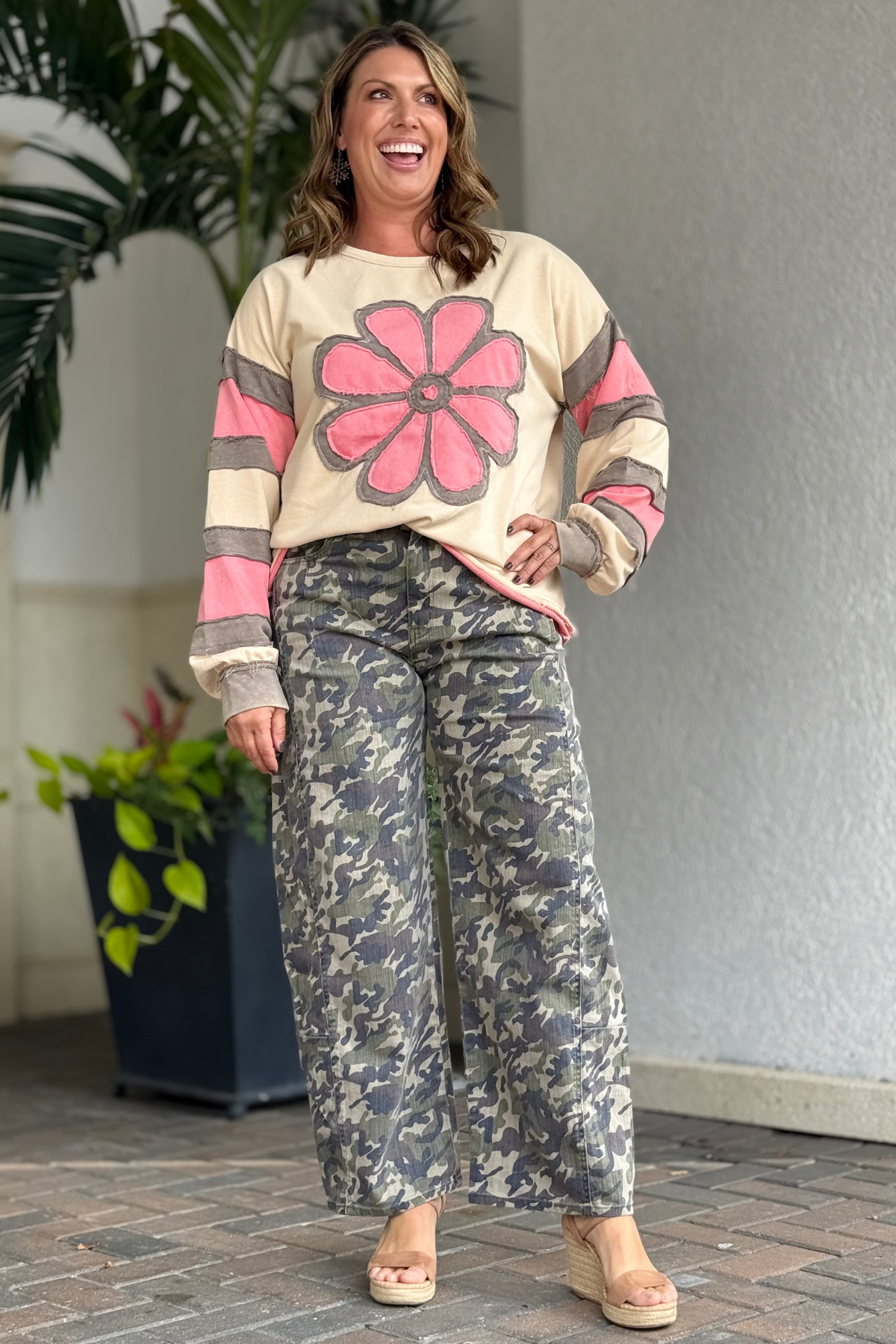 Woman wearing cropped camo barrel jeans with wide leg fit and casual styling